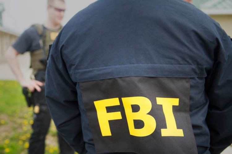 Męska postać odwrócona tyłem z wyraźnym żółtym napisem FBI